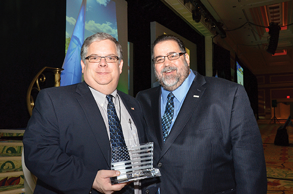 Scott Zaremba, owner of seven gas stations offering E15, accepts the Industry Award from RFAâ€™s Bob Dinneen.