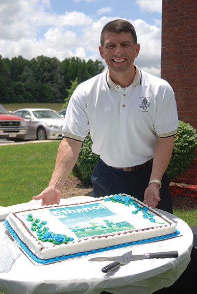 John Caupert, director of the National Corn-to-Ethanol Research Center, shows off a cake decorated with a mock-up of an Ethanol Producer Magazine cover. NCERC kicked off its 10-year celebration during the FEW attendee tour held June 13. 