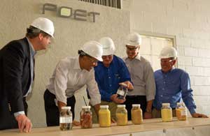 Steve Burnett, general manager of Poet Biorefining, Macon, holds a sample of ethanol during the president's April 28 tour of the facility. To his left are Secretary of Agriculture Tom Vilsack and President Obama, and to Burnett's right are Poet CEO J